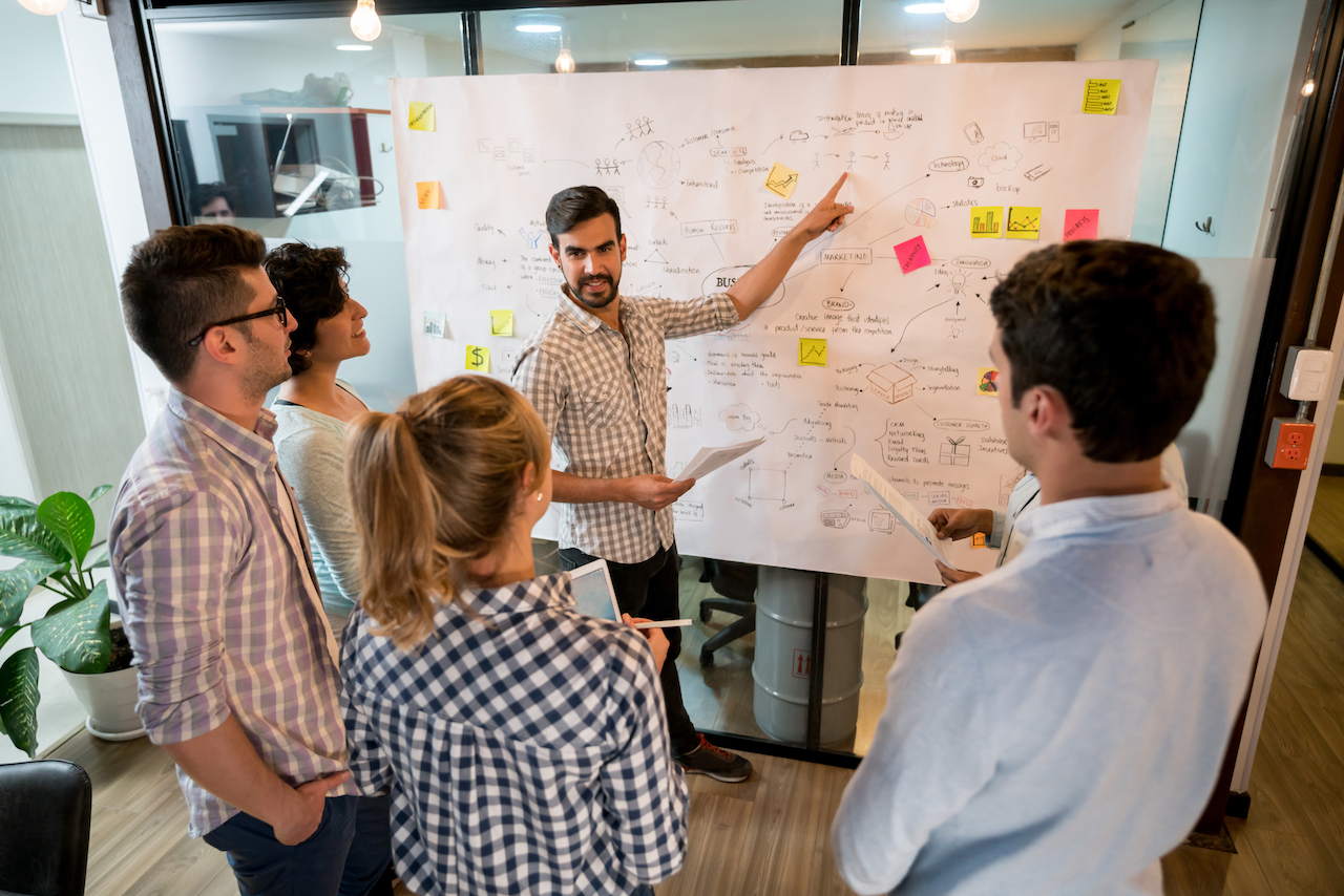 Man in a business meeting at the office pointing at a business plan les acteurs de l'écosystème Daynamics